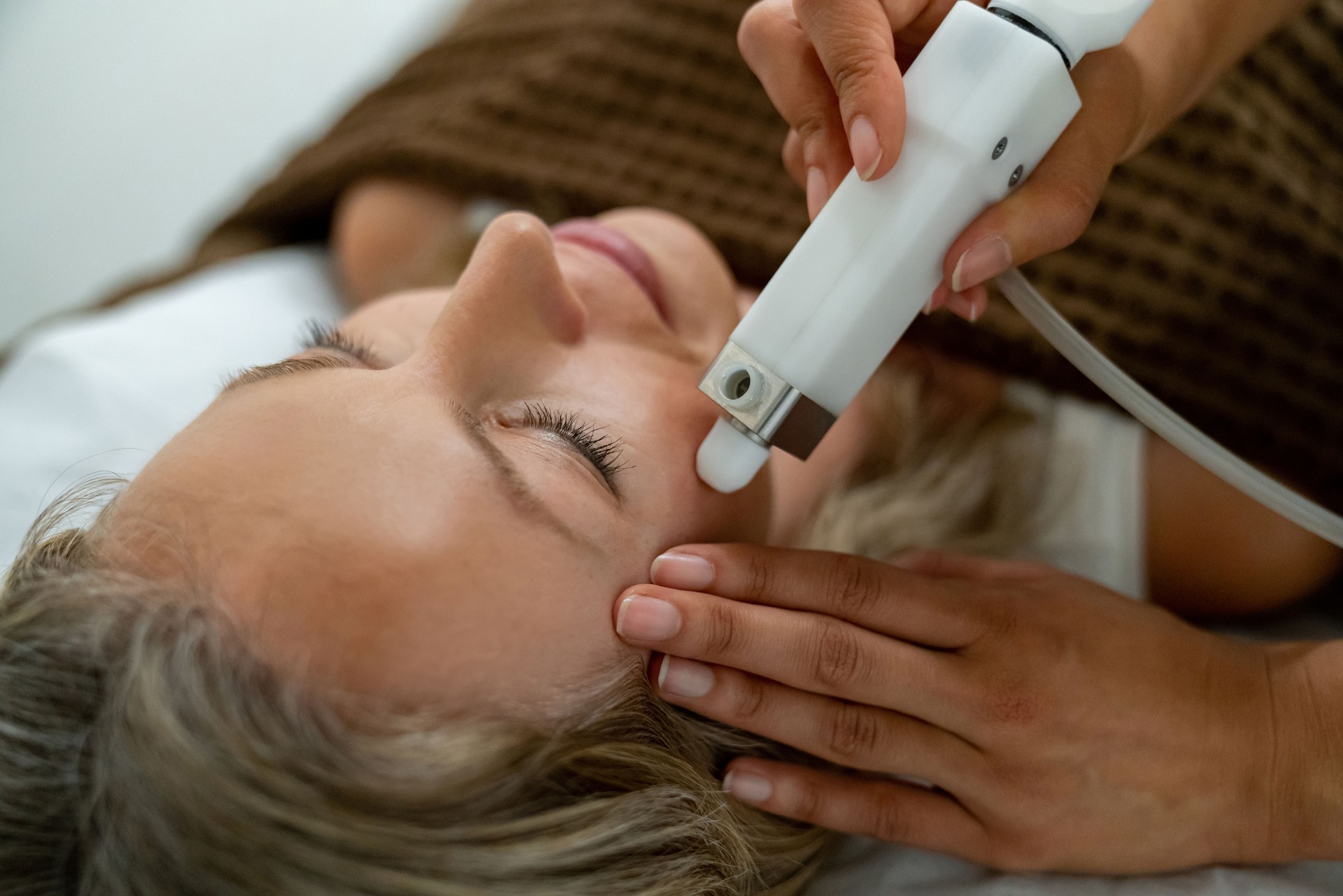 Woman at the spa getting a facial laser treatment